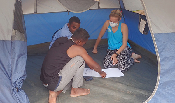 Hailey Reeves meets with two nurses inside of a tent in Madagascar