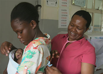 Nurse tending to a woman and her baby
