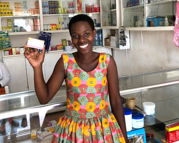 A member of the Malkia Klabu program in Tanzania, which provides HIV self-tests and contraceptives for adolescent girls and young women, shows off her loyalty card.