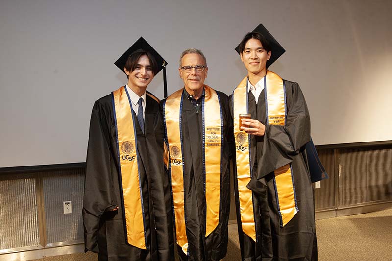Bruce Agins between graduating students James Roake and Anthony Lee.